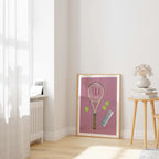 Pink Court Classics framed tennis racket print beside a window and a wooden stool.