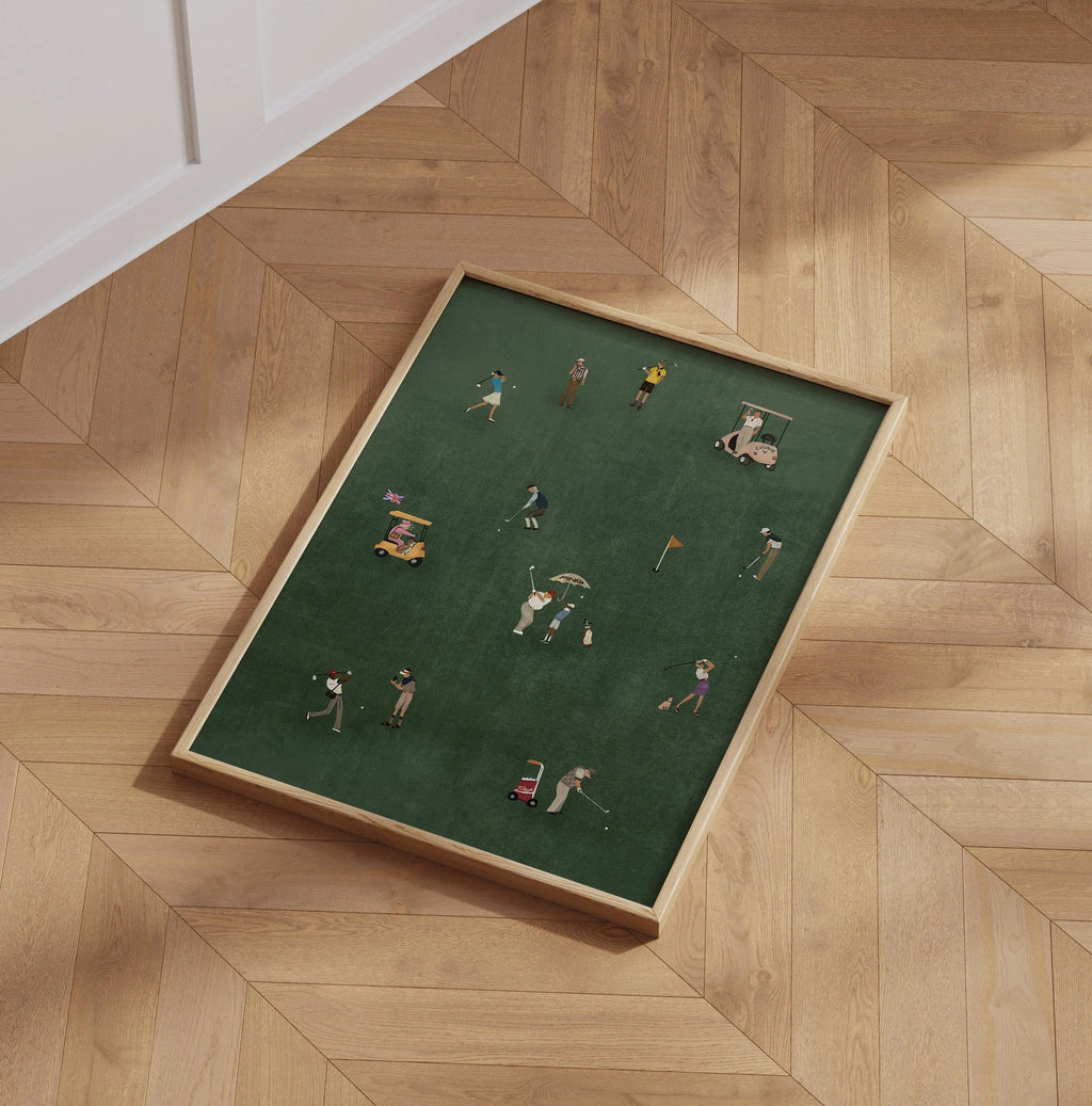 Framed artwork of miniature golfers on a green background, displayed on a wooden floor.