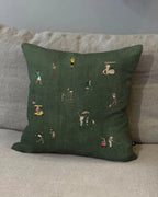 Dark green Tiny Golfers pillow styled on a beige sofa.