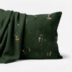 Dark green Wolf Of Golf Street pillow with illustrated golfers beside a matching throw.