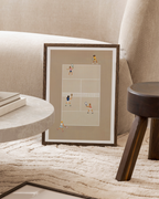 Double Delight beige tennis court print in a dark frame beside a cream sofa.