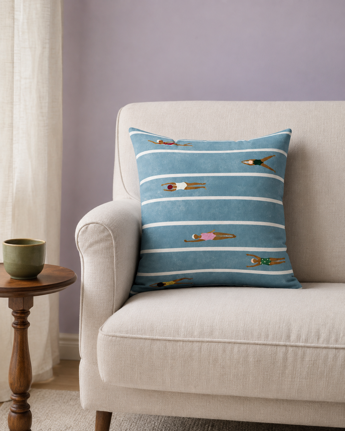 Blue swimming-lanes pillow styled on an ivory armchair; lifestyle visualisation.